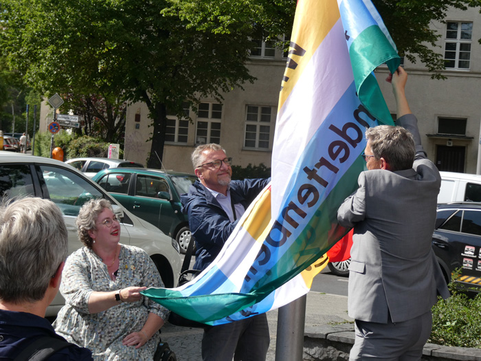 Katja Daus und Jörn Oltmann beim Hissen der Fahne zum "Disability Pride Month"